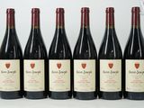 six bottles of wine are lined up in a row on a table