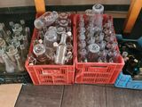 many empty glass bottles sitting in crates on the floor
