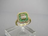 un gros plan d'une bague sertie d'un diamant vert et blanc, posée sur un socle transparent