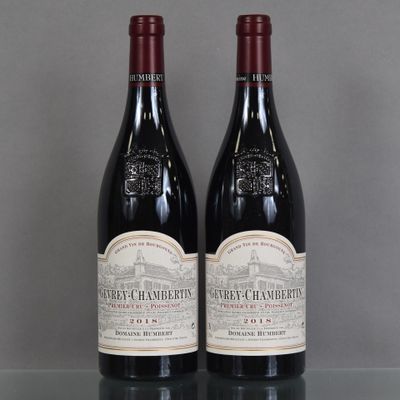two bottles of red wine sitting on top of a glass table