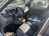 the interior of a silver car with a steering wheel and dashboard