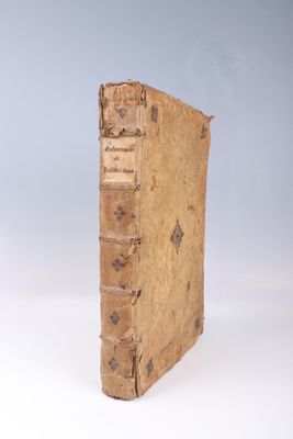 un vieux livre posé sur une table blanche, près d'un mur bleu