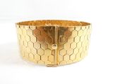 gold tone bracelet with geometric design on a white background