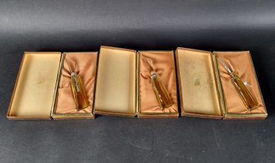 three gold boxes with scissors and a pair of scissors in them