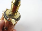 a person holding a small brass object in their hand