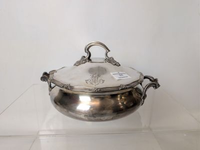 a silver plate with a lid on a glass shelf