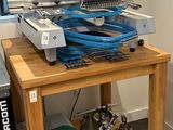 a small table with a bunch of sewing machines on it