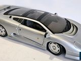 a silver model of a sports car on a white surface