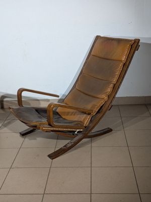 a brown leather chair sitting in a corner of a room