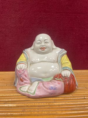 une figurine représentant un Bouddha souriant, posée sur une table