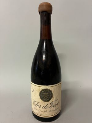an old bottle of wine sitting on top of a table