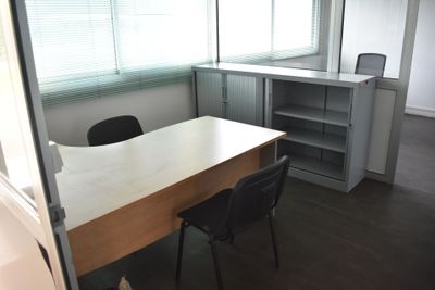 un bureau avec une chaise et une bibliothèque dans un coin