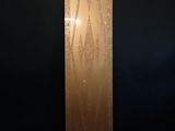 a tall metal sculpture in a dark room with a black wall