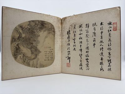 un livre ouvert, sur lequel figurent des caractères chinois, posé sur une table