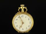 an antique gold pocket watch on a black surface with a reflection