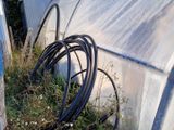 des tuyaux posés dans l'herbe à côté d'un bâtiment