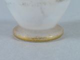 a white bowl with a gold rim on a white surface