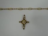 a close up of a gold chain with a cross on it