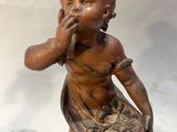 statue d'une petite fille avec un panier de fleurs sur la tête