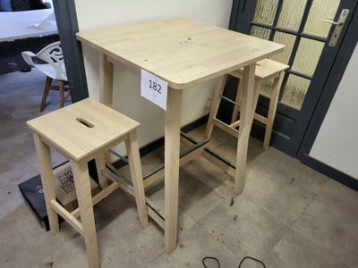 a small table and two stools in a room