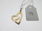 un gros plan sur un pendentif en forme de cœur en or avec une étiquette de prix