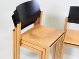 two wooden chairs and a table with a black leather seat