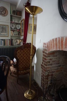 un grand lampadaire doré dans un coin du salon