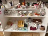 une étagère blanche sur laquelle sont posés de nombreux plats et tasses