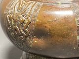a bronze vase with a lid sitting on a table