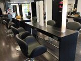 une photo d'un salon avec des chaises et des tables noires