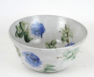 a white bowl with blue and green flowers on it