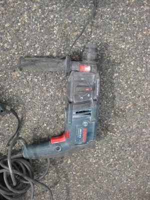 a corded drill sitting on the ground next to a corded cord