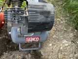 a small air compressor sitting on the ground next to a fire hydrant