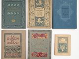 plusieurs vieux livres sont alignés sur une surface blanche