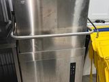 un réfrigérateur en acier inoxydable et des tabourets jaunes dans une pièce