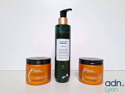 un flacon de lotion et deux pots de lotion posés sur une table