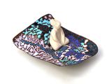 a small plate with a figurine sitting on top of it