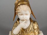 une image représentant la statue d'un garçon portant un chapeau sur la tête