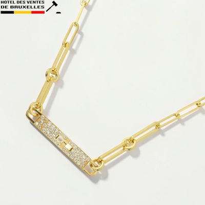 un gros plan d'un collier en or serti de diamants sur fond blanc