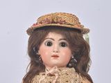 a doll that is wearing a dress and a hat