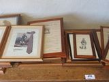 a lot of framed pictures on a table in a room