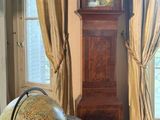 a grandfather clock in the corner of a room with a globe on the floor