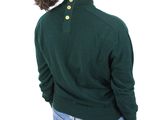 the back of a woman wearing a green sweater and jeans