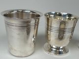 two silver cups sitting next to each other on a table