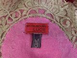 the label of a pink dress is on a lace table cloth