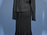 a black dress and jacket on a mannequin stand