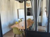 a room with a table, chairs, and a mirror on the wall
