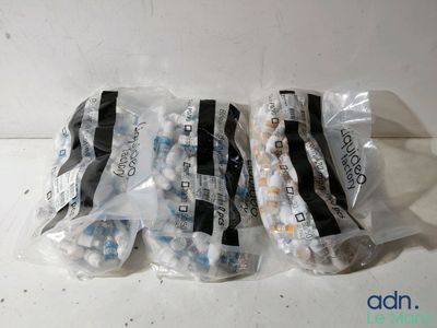 trois sachets de comprimés sont posés les uns à côté des autres sur une table