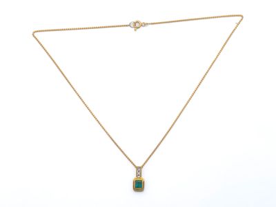 un collier en or avec un pendentif en pierre verte au bout d'une chaîne