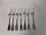 six forks that are sitting next to each other on a table